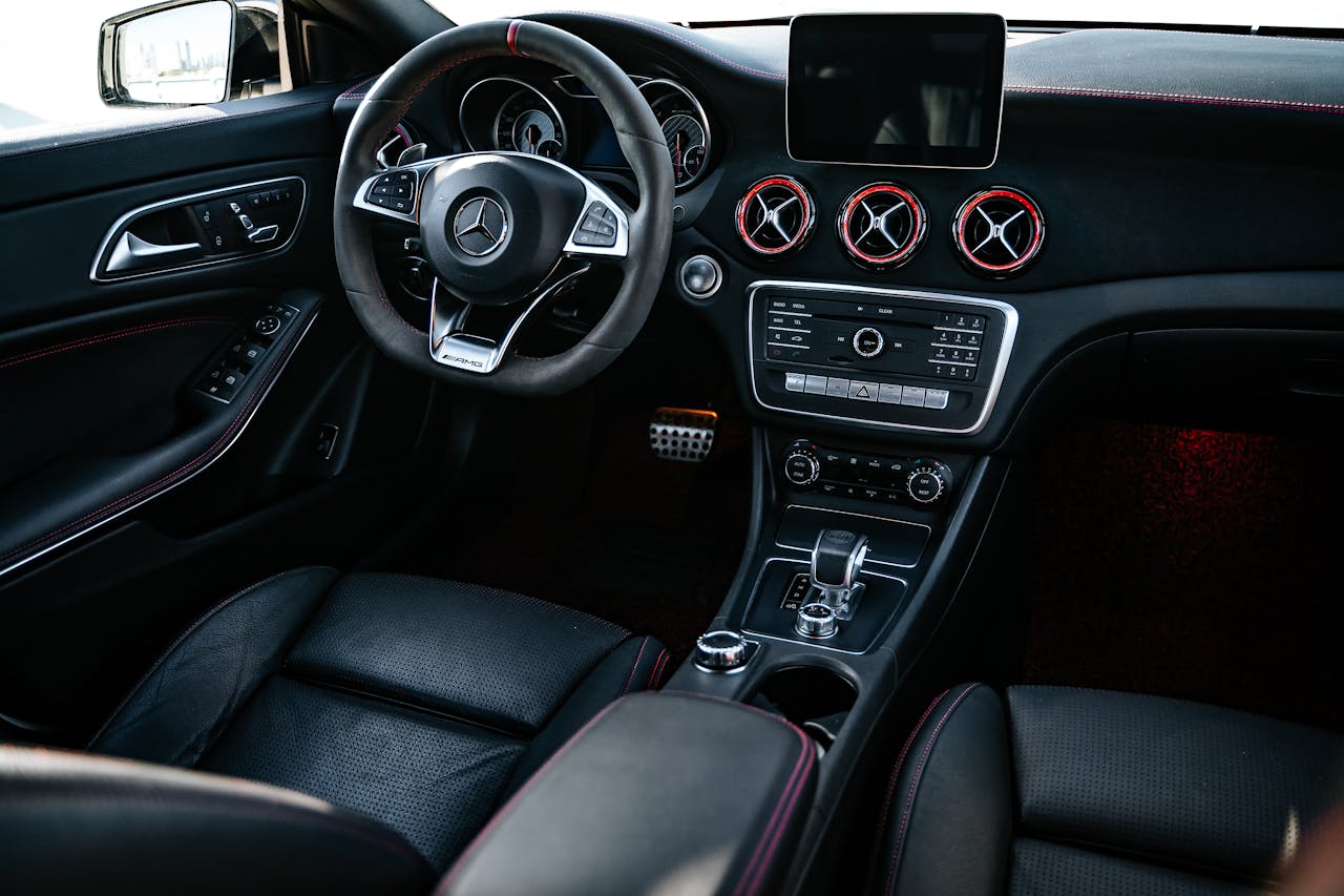 Elegant black car interior showcasing modern dashboard and steering wheel design.